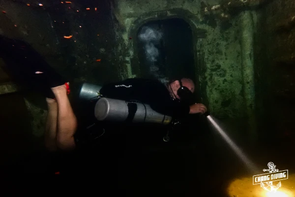 Inside the HTMS Chang wreck – diver entering a dark corridor